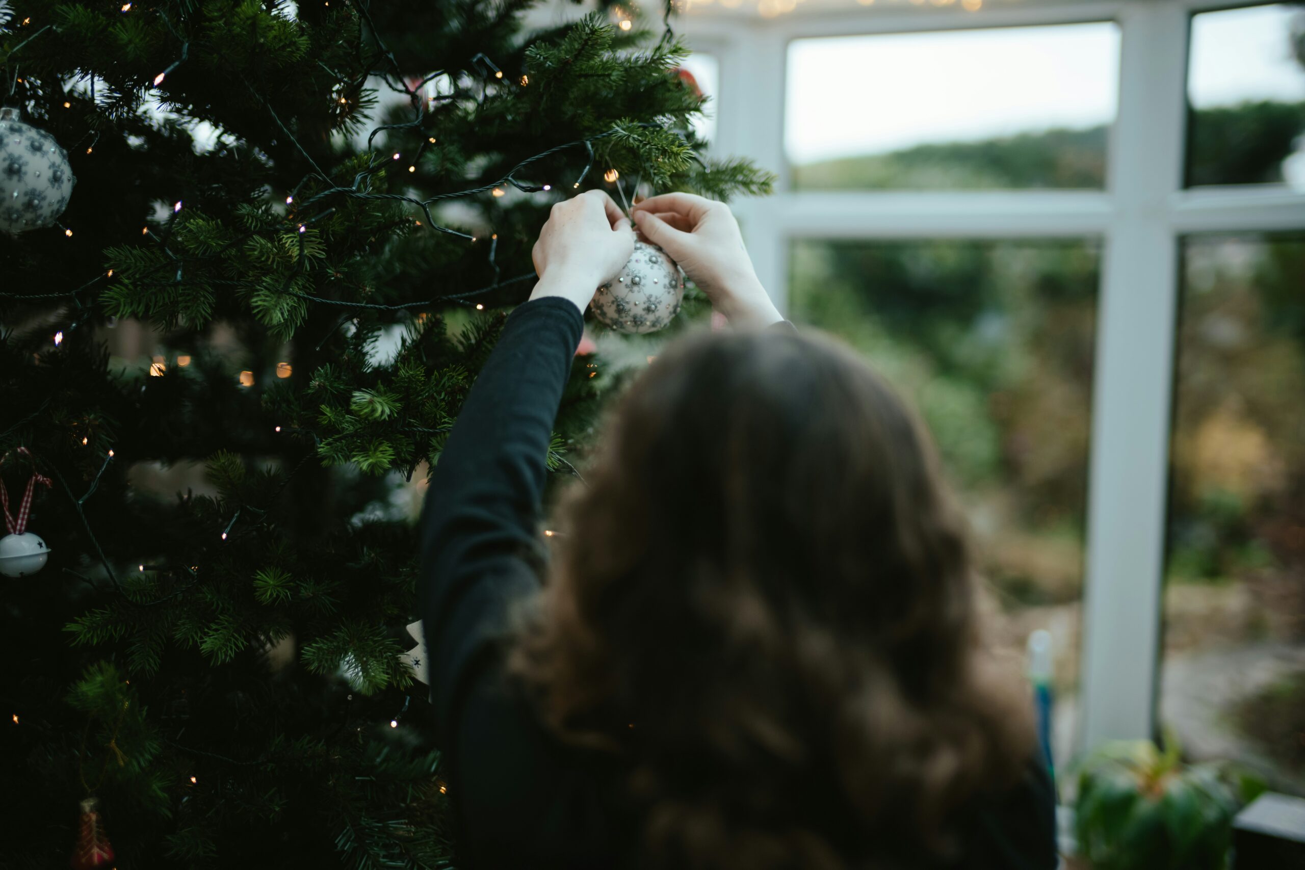 A women decorating her Chirstmas Tree